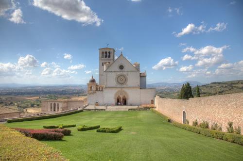 a church on a hill with a large grass yard at Alba dei Due Soli B&B in Nocera Umbra