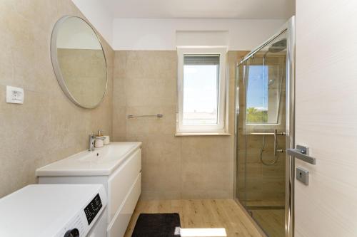 a bathroom with a sink and a mirror at Apartments St VITUS in Privlaka