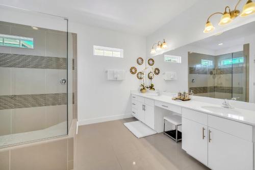 a white bathroom with two sinks and a shower at The Carpe Diem in Orlando