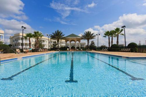 a large swimming pool in a resort with palm trees at The Carpe Diem in Orlando