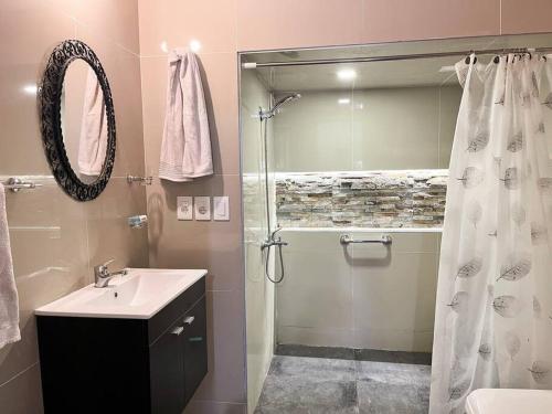 a bathroom with a shower and a sink and a mirror at Casa en Piriapolis in Piriápolis