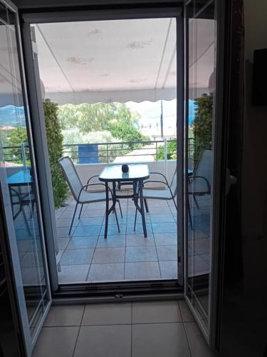 a glass door leading to a patio with a table and chairs at Valta's Room 2 in Paleros