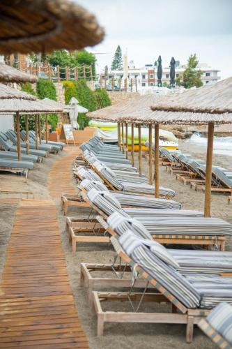 a row of lounge chairs and umbrellas on a beach at AKASHA Beach Hotel & Spa in Hersonissos
