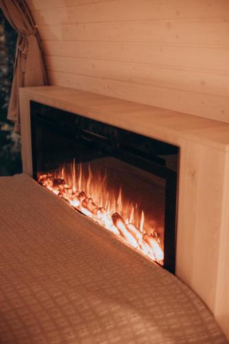 a fire in a fireplace in a room at Fairytale Guest House & SPA in Jaunkrimulda