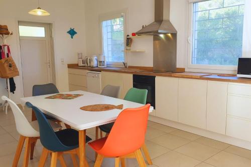 - une cuisine avec une table et des chaises blanches dans l'établissement Villa U rustincu, à Pietrosella