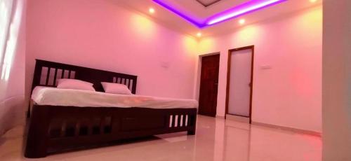 a bedroom with a bed with purple lights on the ceiling at La Bay Luxury Beach Bungalow in Puducherry