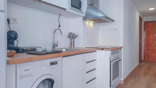 a kitchen with a sink and a washing machine at Apartamento Fani Oro in Oropesa del Mar