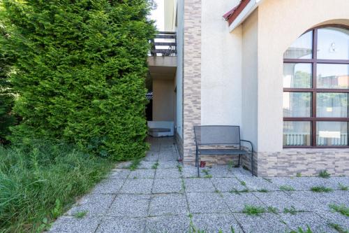 a chair sitting outside of a building next to a bush at FarawayHomes Aparthotel Near Vienna Airport - Anytime Self Check-In in Bruck an der Leitha