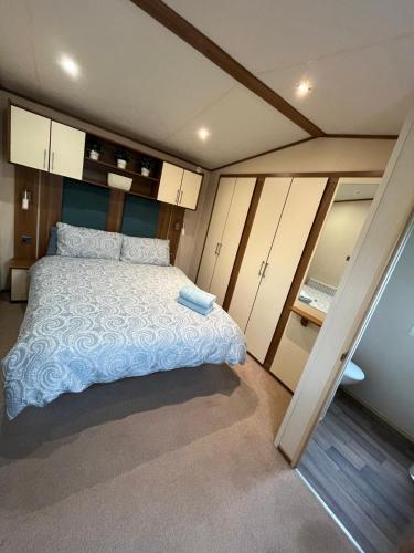a bedroom with a large bed and some cabinets at Tattershall Lakes in Tattershall
