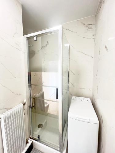 une salle de bain avec toilettes et douche en verre dans l'établissement Apartment My HOME Eiffel Tower View, à Paris