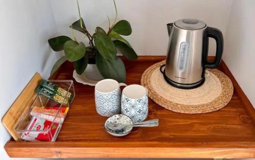 ein Tisch mit einem Teekessel und Tassen darauf in der Unterkunft Verdiend En-suite Unit at Ngweni Private Game Farm in Hluhluwe