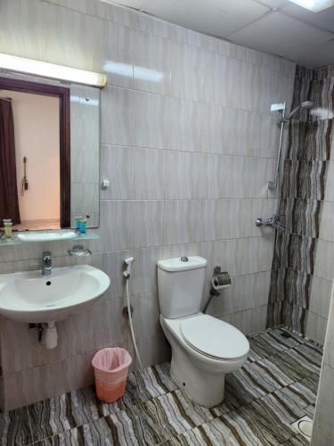 a bathroom with a toilet and a sink at iQama 2 in Salalah