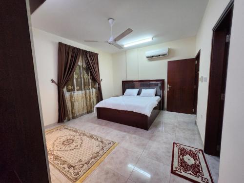 a bedroom with a bed and a window at iQama 2 in Salalah