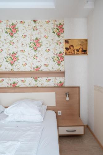 a bedroom with a bed with a painting on the wall at FarawayHomes Aparthotel Near Vienna Airport - Anytime Self Check-In in Bruck an der Leitha