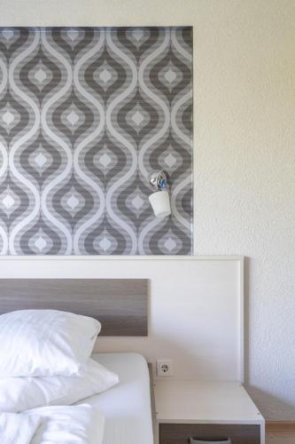 a bedroom with a bed and a wall with a wallpaper at FarawayHomes Aparthotel Near Vienna Airport - Anytime Self Check-In in Bruck an der Leitha