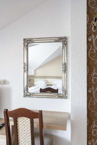 a mirror on a wall above a table with a chair at FarawayHomes Aparthotel Near Vienna Airport - Anytime Self Check-In in Bruck an der Leitha