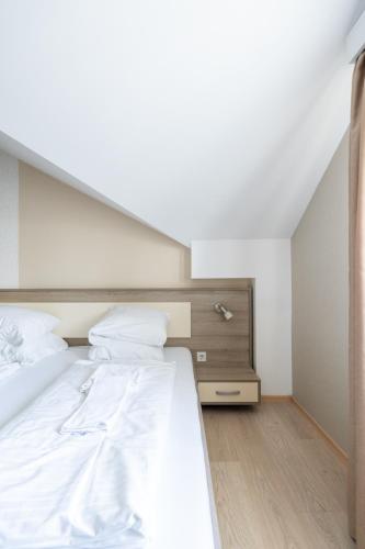a bedroom with a large bed with white sheets at FarawayHomes Aparthotel Near Vienna Airport - Anytime Self Check-In in Bruck an der Leitha