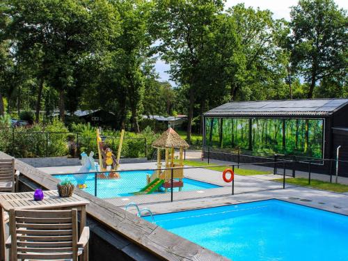 a swimming pool with a playground and a gazebo at Spacious Villa in Hoenderloo in Hoenderloo