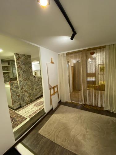 ein Wohnzimmer mit einem großen Fenster und ein Zimmer mit in der Unterkunft Deenco apartment in Sarajevo