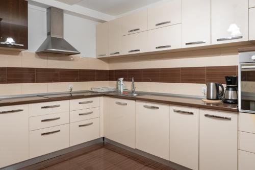 a kitchen with white cabinets and stainless steel appliances at FarawayHomes Aparthotel Near Vienna Airport - Anytime Self Check-In in Bruck an der Leitha