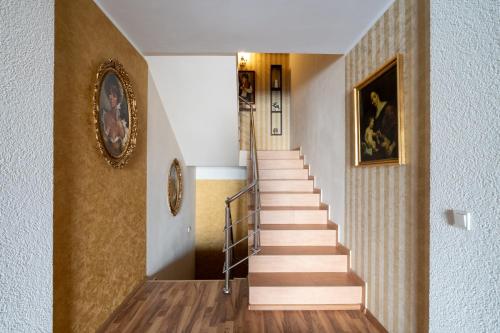 a staircase in a building with a picture on the wall at FarawayHomes Aparthotel Near Vienna Airport - Anytime Self Check-In in Bruck an der Leitha