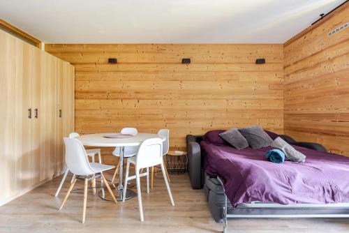 a bedroom with a bed and a table and chairs at L'Alpage - Serre Chevalier in Saint-Chaffrey