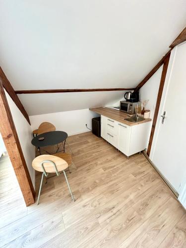 une petite pièce avec une table et une cuisine dans l'établissement Le Victor, à Coulommiers