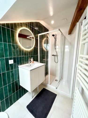 une salle de bain avec un lavabo et une douche dans l'établissement Le Victor, à Coulommiers