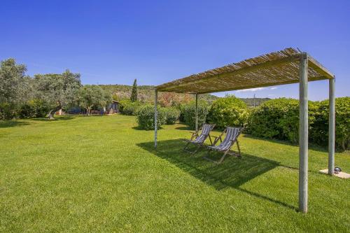 two chairs under a gazebo in a yard at Chalet Vignarola - Happy Rentals in Orbetello
