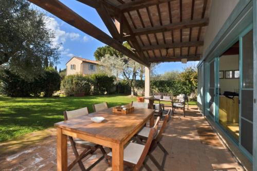 a wooden table and chairs on a patio at Chalet Vignarola - Happy Rentals in Orbetello