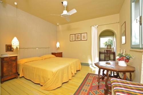 a bedroom with a bed and a table and a window at Chalet Vignarola - Happy Rentals in Orbetello