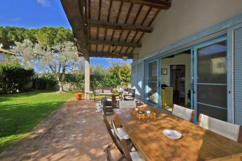 a wooden table and chairs on a patio at Chalet Vignarola - Happy Rentals in Orbetello
