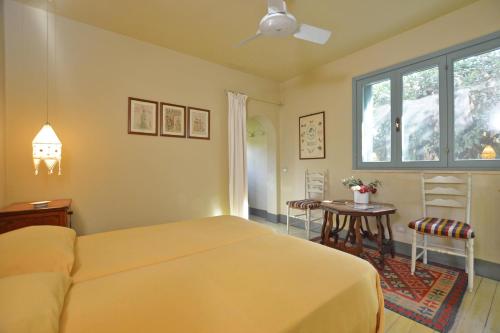 a bedroom with a bed and a table and a window at Chalet Vignarola - Happy Rentals in Orbetello