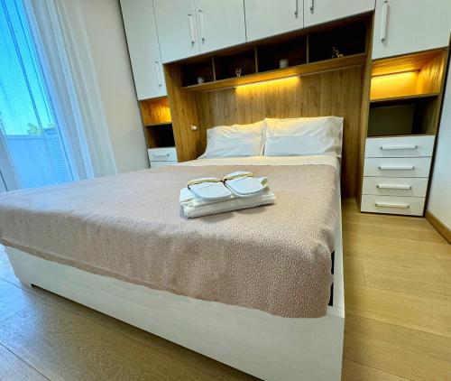 a bedroom with a large bed with two glasses on it at Appartamento Rimini Chanel in Rimini
