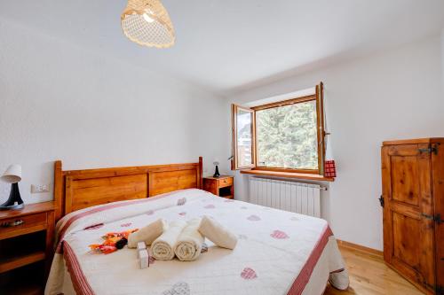 a bedroom with a bed and a window at Miramonti 21 Ski In - Ski Out - Happy Rentals in Sauze dʼOulx