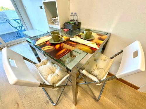 a glass table with two chairs and food on it at Appartamento Rimini Chanel in Rimini