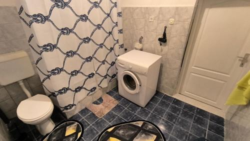 a bathroom with a toilet and a shower curtain at Todoroski House in Ohrid