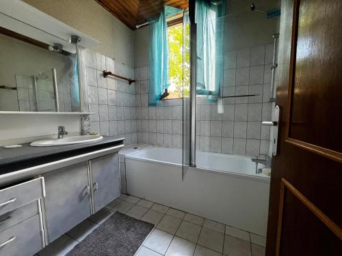 une salle de bain avec une baignoire, un lavabo et une douche dans l'établissement la tranquillité à l'état pur, à Sainte-Geneviève-des-Bois