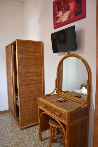 a dressing table with a mirror and a tv on a wall at Holiday Home Gionny & Mary in Taormina