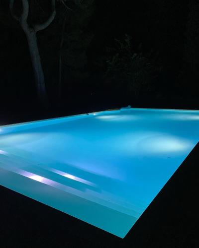 a blue swimming pool at night at Villa9centob&b in Castel di Lama