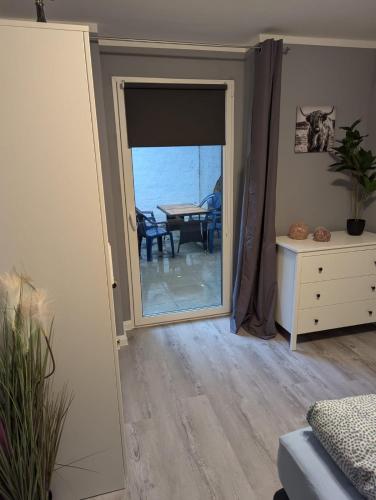 a room with a door open to a dining room with a table at Stadtnah an der Förde 7 HH M EG in Flensburg