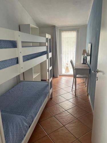 a bedroom with two bunk beds and a desk at Morbegno holiday house in Morbegno