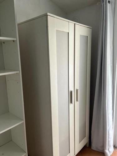 a white cabinet in a room with a curtain at Morbegno holiday house in Morbegno