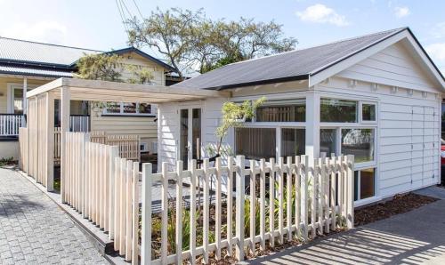 a white fence in front of a house at Stylish Eden Park Studio in Auckland