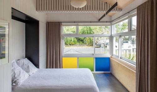 a bedroom with a bed and a large window at Stylish Eden Park Studio in Auckland