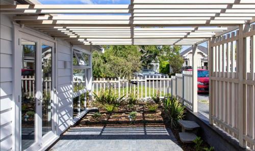 a pergola on a house with a garden at Stylish Eden Park Studio in Auckland