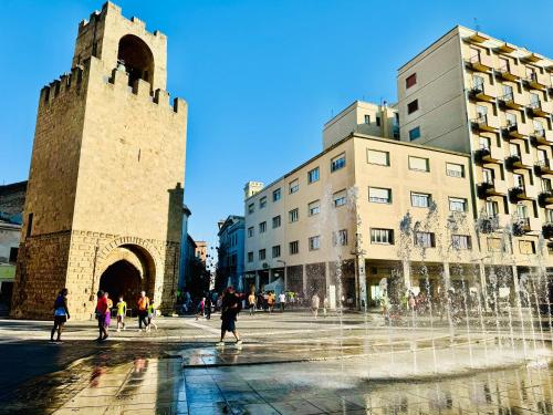 a fountain in the middle of a city with buildings at Feel Boutique Rooms in Oristano