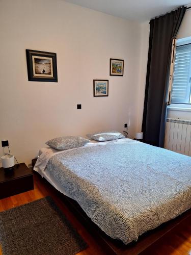 a bedroom with a bed with a blue comforter at Apartment Vidak in Labin