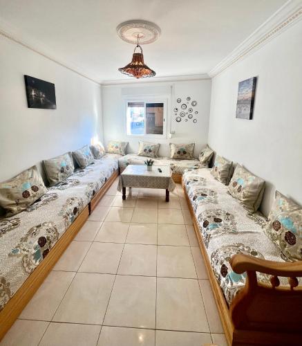 a living room with a long couch and a table at moderno apartamento en el centro , a 3 min del mar I in Asilah