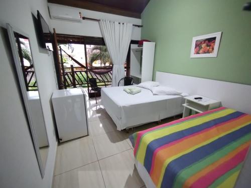 ein Hotelzimmer mit zwei Betten und Balkon in der Unterkunft Pousada Água Marinha in Caraguatatuba